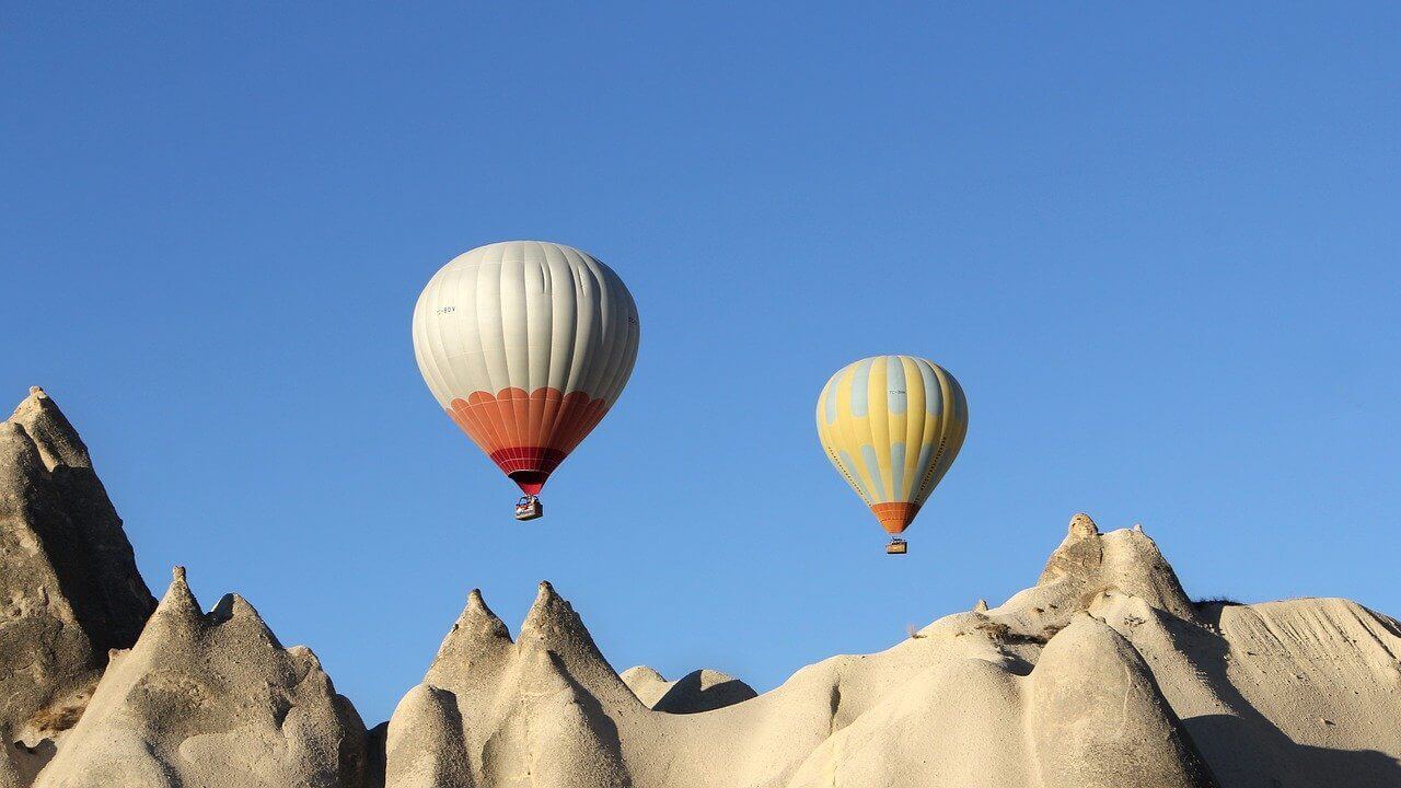 Dwa latające balony na tle gór